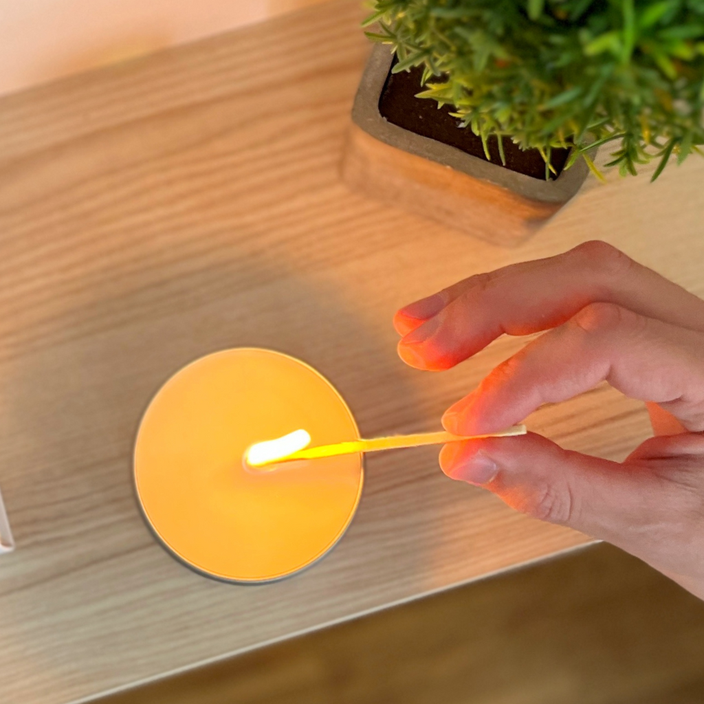Eine hochwertige Duftkerze von Chris P. Candles wird gerade angezündet – sanftes Kerzenlicht beginnt den Raum in warme Herbststimmung zu tauchen.