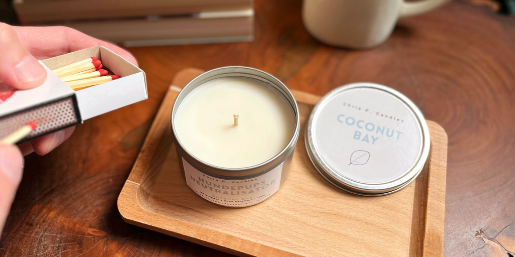 Duftkerze in Dose ‚Hundepups Neutralisator‘ auf Holztisch. Stilvolle Metalldose mit frechem Spruch, sorgt für humorvolle und gemütliche Atmosphäre in Wohnzimmer, Küche oder Bad. Ideal als Geschenk für Hundebesitzer oder Tierliebhaber.