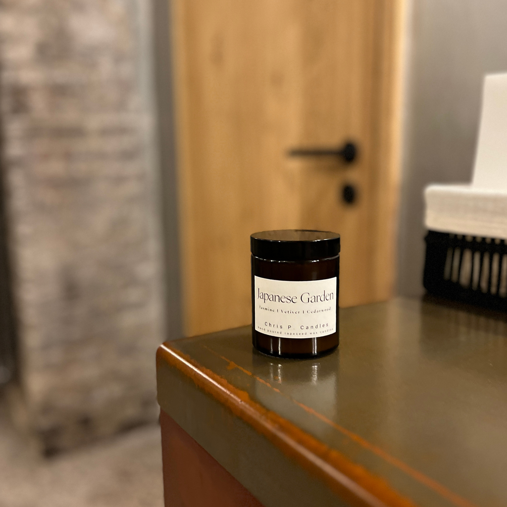 Glas-Duftkerze ‚Japanese Garden‘ auf Badezimmertisch. Stilvolles Glasdesign, schafft entspannte Atmosphäre beim Baden oder Duschen. Perfekt für Home-Spa, Wellness-Momente oder als Geschenk.