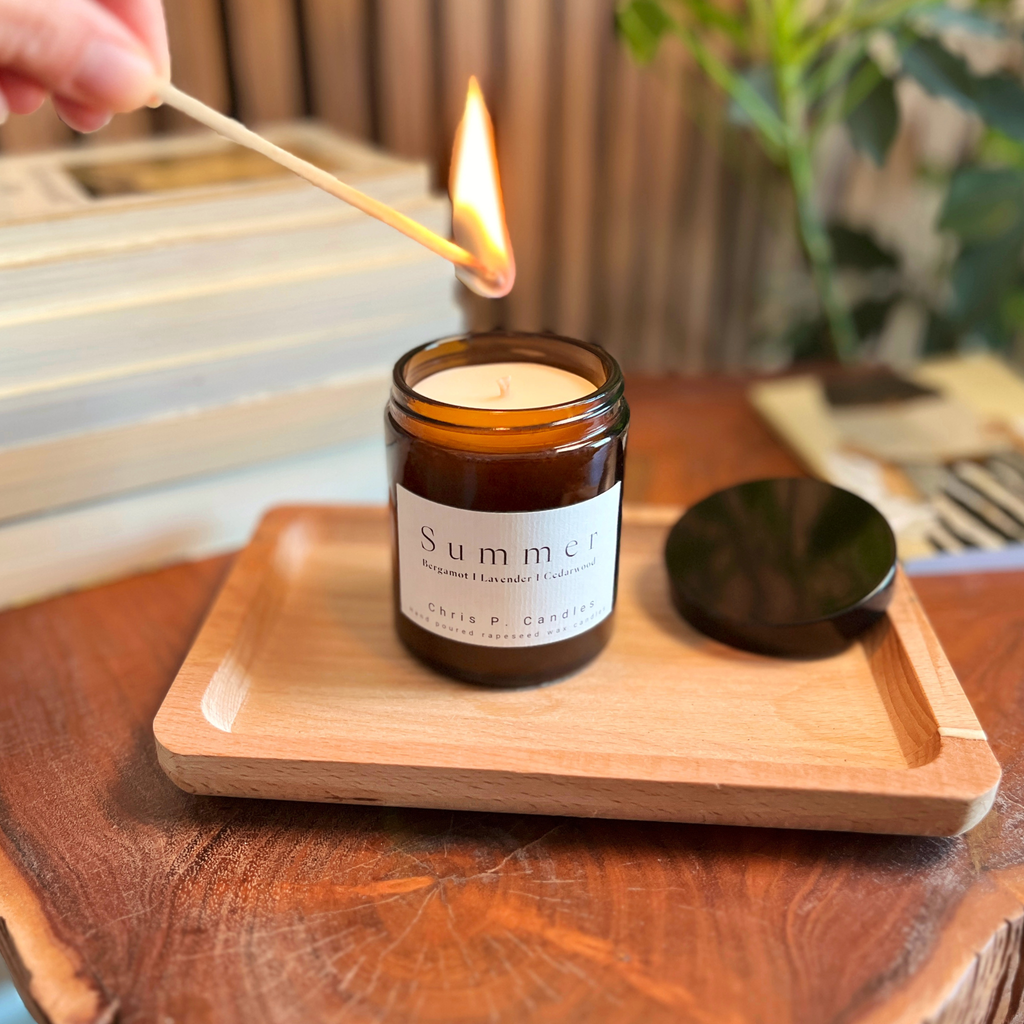 Die Summer Duftkerze im Glas von Chris P. Candles steht auf einem Holztisch und verströmt Bergamotte, Lavendel und Zedernholz für eine entspannte Sommerstimmung.