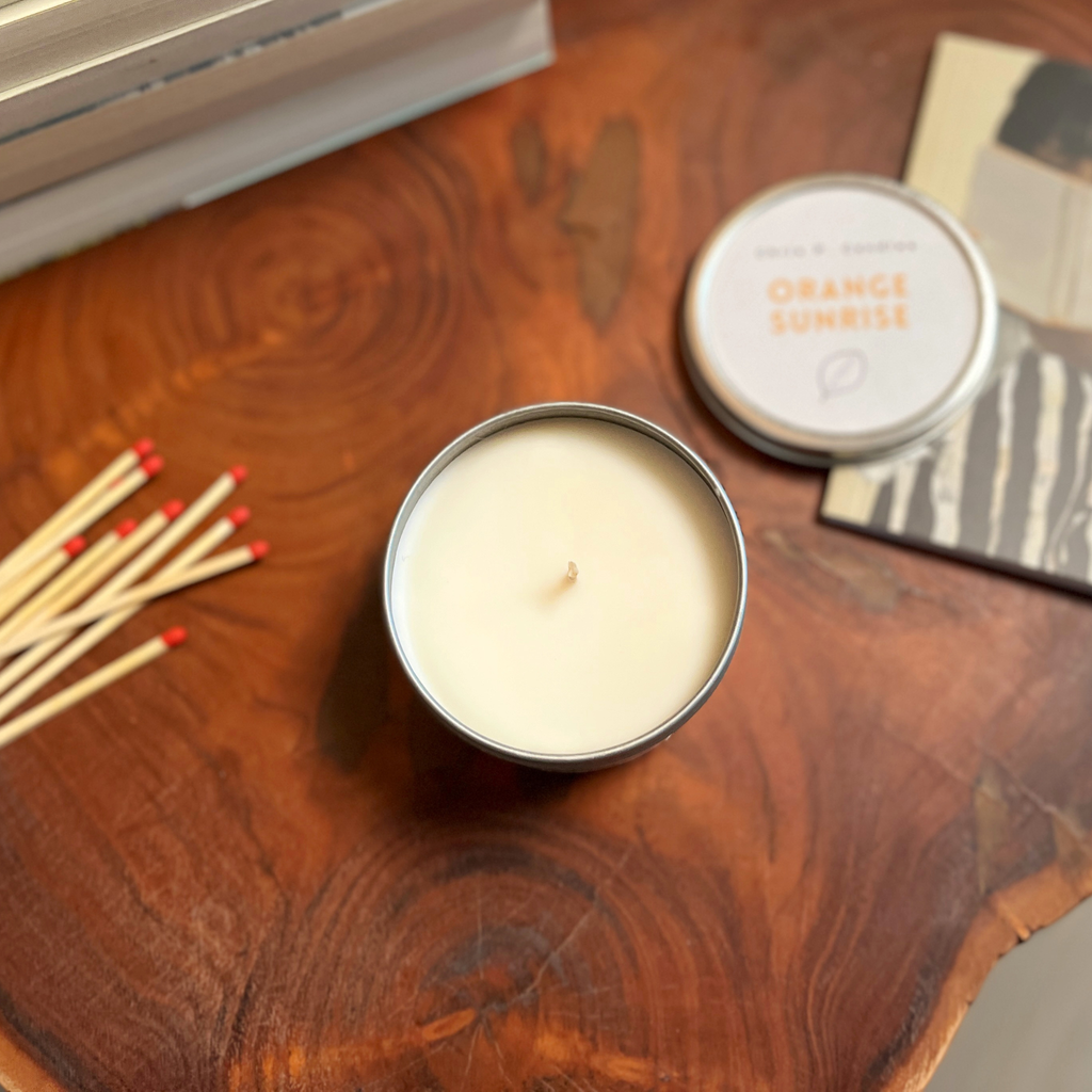 Orange-Sunrise-Duftkerze auf einem Holztisch im gemütlichen Wohnzimmer – handgemachte Rapswachs-Kerze, lang brennend, mit lustigem Spruch, dekorative Kerze, Geschenk für Freundin, Wohn-Deko mit Spaßfaktor.