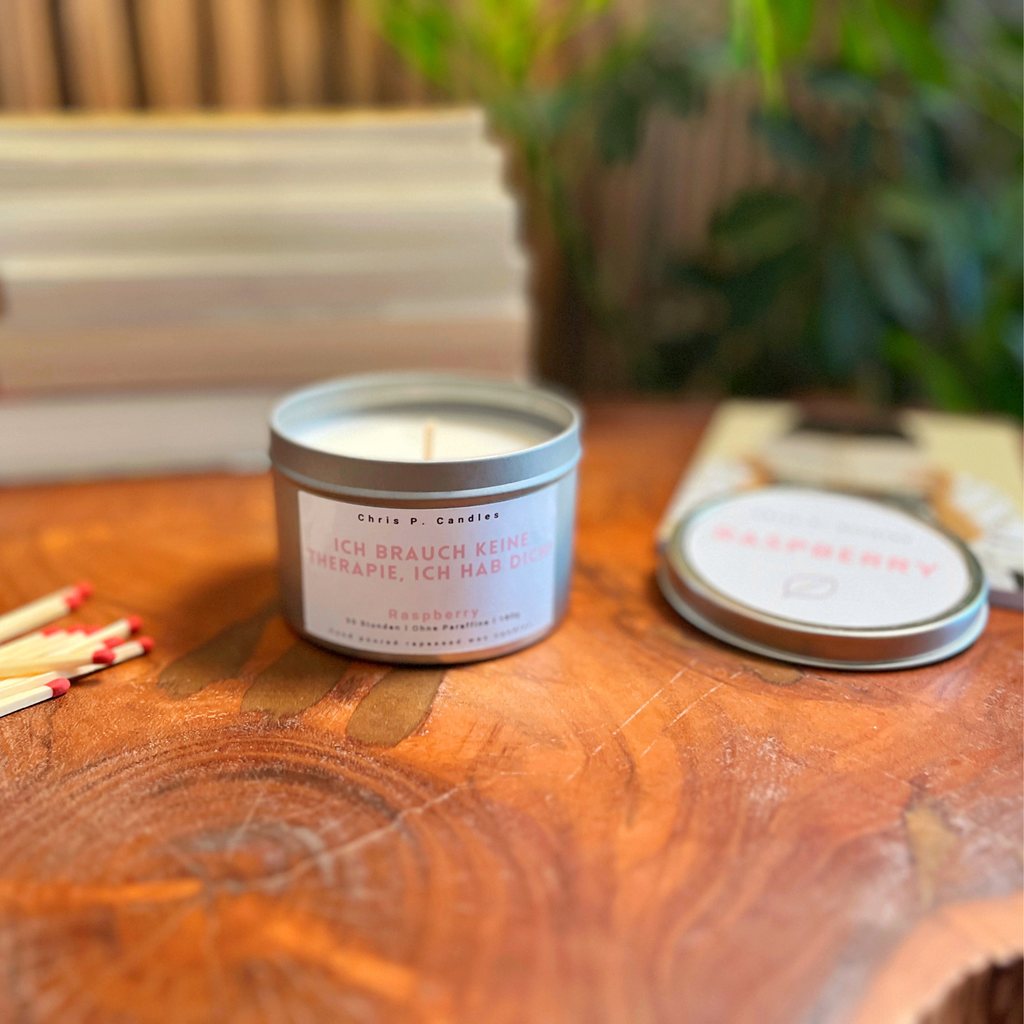 Raspberry-Duftkerze von Chris P. Candles auf Tisch in wohnlicher Atmosphäre – hand-poured, Rapswachs, beste Kerze aus Berlin. Lustiger Spruch auf Duftkerze mit Himbeer-Duft ist die perfekte Geschenkidee für Freundin oder für dich als dekorative Wohn-Deko.